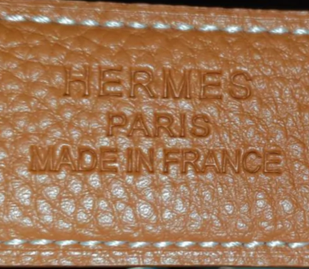 Gros plan sur inscription Hermes sur la ceinture de la marque Hermes.